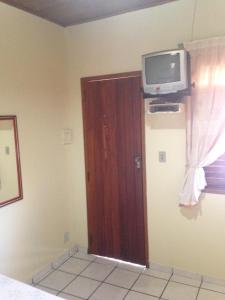 una camera con una porta con una TV a parete di Pousada Visual a Arraial d'Ajuda