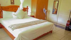 a bedroom with a large white bed in a room at Avon Garden Lodge in Salima