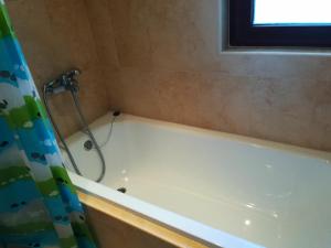 ein Badezimmer mit einer Badewanne mit Duschvorhang in der Unterkunft Apartments Elegance in Bansko
