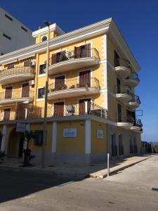 a yellow building with balconies on the side of it at Traiano Suite in Margherita di Savoia