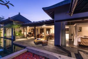 una casa con terrazza, letto e soggiorno di Ayuterra Resort ad Ubud