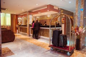 a lobby with a luggage cart in front of a bar at Tiffany Diamond Hotel Makunganya Street in Dar es Salaam