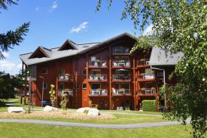 a large red building with balconies at Résidence Néméa Le Nevez in Les Contamines-Montjoie