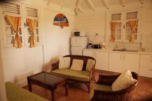 a kitchen with a couch and a chair and a table at BUNGALOW BASSIN TROUVE in Sainte-Anne