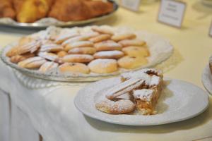 un tavolo con un piatto di ciambelle e un piatto di prodotti da forno di La Rocca Sport & Benessere a Châtillon