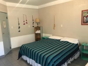 1 dormitorio con 1 cama con manta de rayas azules en Posada Casa de Borgoña en Salta