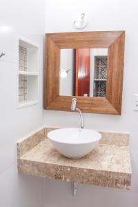 a bathroom with a sink and a mirror at Pousada Aldeia dos Ventos in São Pedro da Aldeia +50 photos
