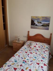 een slaapkamer met een bed met een kleurrijk dekbed bij Precioso chalet con mar a 50 metros. in Chilches