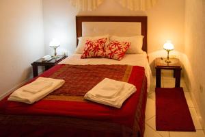 1 dormitorio con 1 cama con 2 toallas en Hotel & Restaurante Guarania en Ciudad del Este