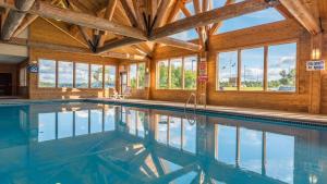 an indoor pool in a house with wooden ceilings and windows at Grand Ely Lodge in Ely