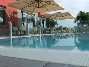 an empty swimming pool with umbrellas and chairs at Hotel Rio Bellaria in Bellaria-Igea Marina