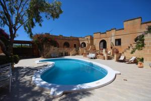 a swimming pool in the middle of a patio at Satori Gozo Centre - Apartment Bufo in Xagħra