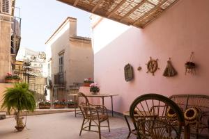 un patio con sedie e tavolo in un edificio di I Balconi sul Barocco a Modica