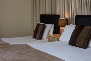 a hotel room with two beds and a table with a lamp at Northallerton Motel in Northallerton