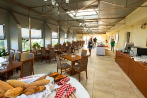 restauracja ze stołami i krzesłami oraz chodzącymi ludźmi w obiekcie Dolphin Resort & Conference w mieście Kalamos