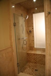 
a bathroom with a shower, sink, and toilet at The Atrium Resort in Grace Bay
