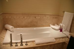 a bathroom with a bath tub with towels on it at The Atrium Resort in Grace Bay