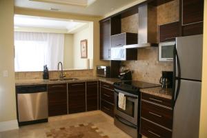 
a kitchen with a refrigerator, stove, sink and microwave at The Atrium Resort in Grace Bay
