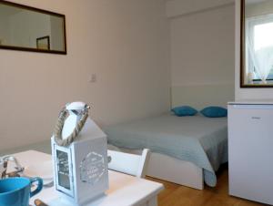 Mały pokój z łóżkiem i stołem z biurkiem w obiekcie Pokoje Gościnne - U Wiktorii w mieście Krynica Morska