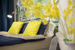 Una cama con almohadas amarillas y azules. en Sanya Sanya Bay·Sanya Bay Tourist Area· Locals Apartment 00164300 en Sanya