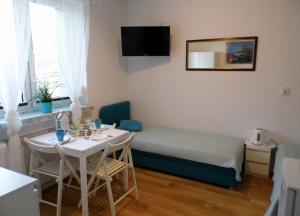 mały pokój z łóżkiem i stołem w obiekcie Pokoje Gościnne - U Wiktorii w mieście Krynica Morska