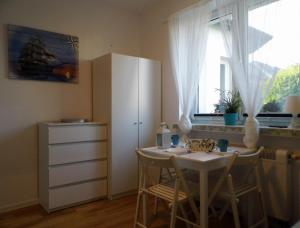 kuchnia ze stołem, szafką i oknem w obiekcie Pokoje Gościnne - U Wiktorii w mieście Krynica Morska