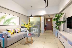 un salon avec un canapé et une table dans l'établissement Sanya Sanya Bay·Sanya Bay Tourist Area· Locals Apartment 00164300, à Sanya