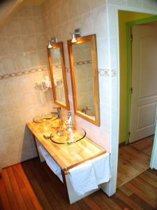 a bathroom with a sink and two mirrors at L'Eternet in Malansac +7 photos