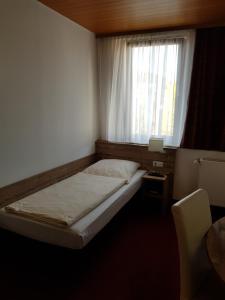 a small bedroom with a bed and a window at Hotel Alte Krone in Tübingen