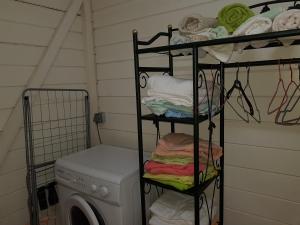 a laundry room with a washing machine and towels at BUNGALOW BASSIN TROUVE in Sainte-Anne
