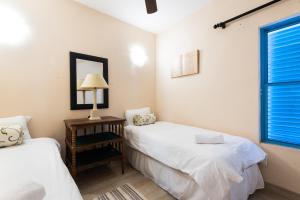 a bedroom with two beds and a mirror and a window at Santorini Kallisti 7 (Family Only) in Ballito