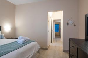 a bedroom with a bed with a blue towel on it at Santorini Kallisti 7 (Family Only) in Ballito