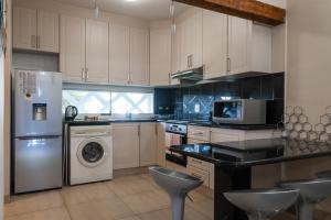a kitchen with a refrigerator and a washer and dryer at Santorini Kallisti 7 (Family Only) in Ballito