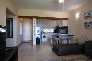 a living room with a couch and a kitchen at Santorini Kallisti 7 (Family Only) in Ballito