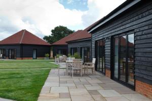 een patio met stoelen en tafels in een tuin bij The Old Flower Field in Hurstpierpoint