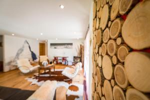 a living room with a wall of logs at Casa Della Vita in Zermatt