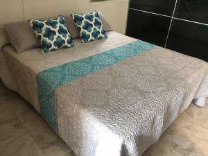 a bed with blue and white sheets and pillows at Monte Rojo San Agustin in San Agustin +25 photos
