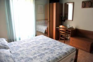 1 dormitorio con cama, escritorio y espejo en Locanda da Cidalie, en Ragogna