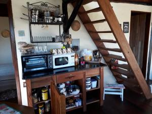 uma cozinha com um balcão com um micro-ondas e uma escadaria em Casinha do Up em Conceição do Ibitipoca