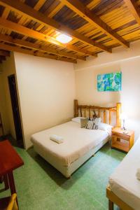 1 dormitorio con 2 camas y techo de madera en Posada Los Tajibos en Puerto Iguazú