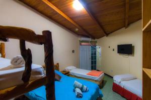 a room with two bunk beds and a flat screen tv at Posada Los Tajibos in Puerto Iguazú