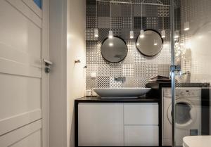 een badkamer met een wastafel en een wasmachine bij Unique 3city Apartments - Ufo Apartment in Gdańsk