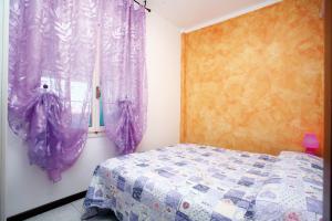 ビビオーネにあるFrancoのベッドルーム1室(紫色のカーテンと窓付きのベッド1台付)