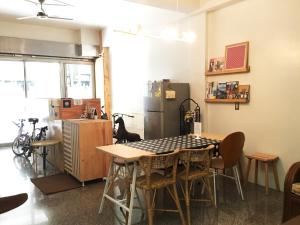 a kitchen with a table and a refrigerator at Tainan Gu Hostel in Tainan