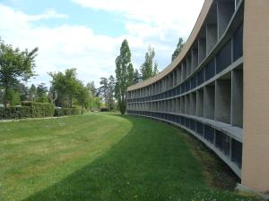 ein Gebäude mit grünem Rasen neben einem Gebäude in der Unterkunft HOTEL RESTAURANT CIRIUS in Montrond-les-Bains