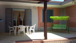 una casa con patio con mesa y sillas en Villa Pina, en Punta Prosciutto