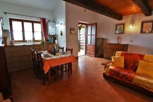 een keuken en een woonkamer met een tafel en een bank bij Appartamento TRE QUERCE di Guerrini Patrizia in Sorano