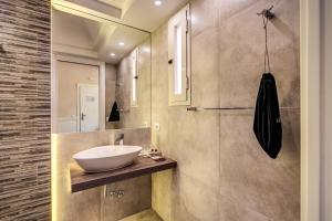 bagno con lavandino e specchio di La Foresteria Luxury Suites a Roma