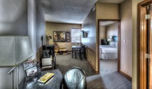 a hotel room with a bedroom with a bed and a desk at Podollan Inn & Spa - Grande Prairie in Grande Prairie