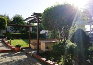 a garden with a wooden pergola and a tree at "The plane trees" in Polykárpion